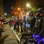 Protesters face off against police officers against shields
